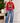Model wearing ENKRIX LUXURY red rhinestone bear hoodie with blue wide-leg jeans
